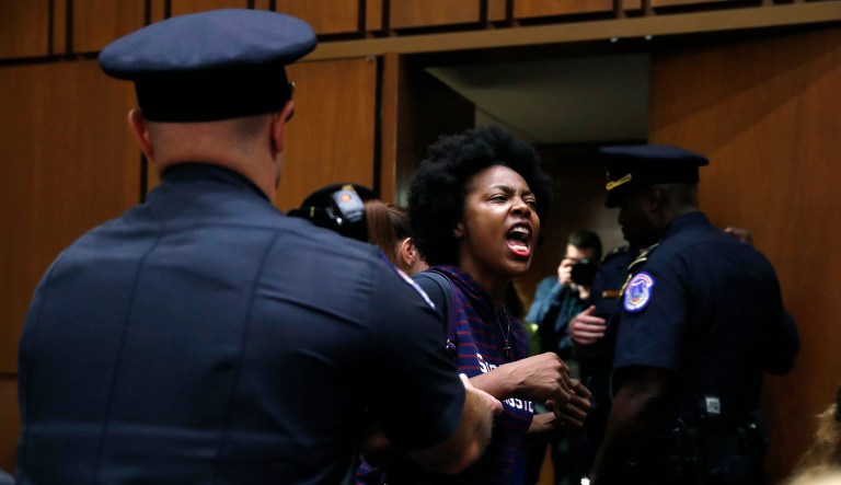 A protester against Supreme Court nominee Brett Kavanaugh is removed from his Senate Judiciary Committee confirmation hearing. 