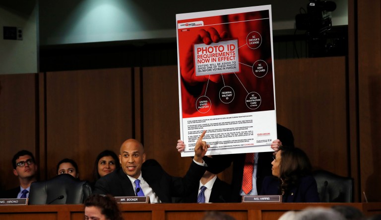 Sen. Cory Booker, D-N.J., points toward an example of voter ID signage as he questions President Trump's Supreme Court nominee, Brett Kavanaugh, as he testifies before the Senate Judiciary Committee on Capitol Hill.