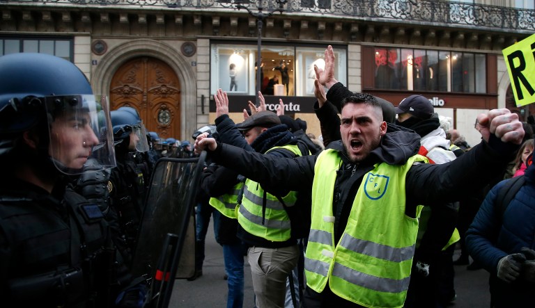 Demonstrators face riot police officers during a protest near the opera house on Saturday in Paris.