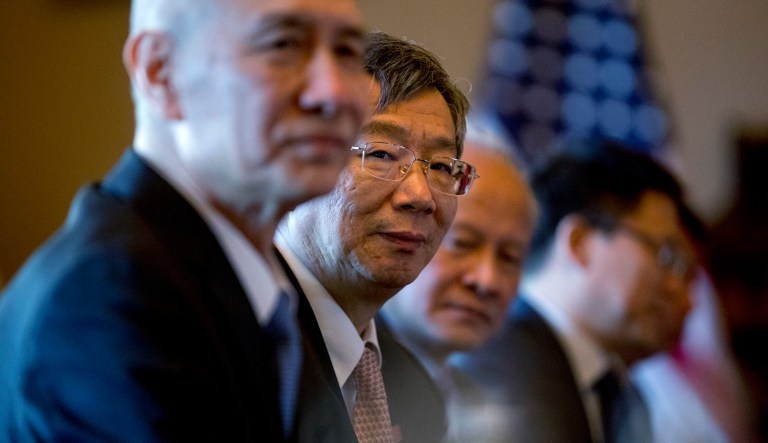 China's Central Bank Governor Yi Gang, center, accompanies Chinese Vice Premier Liu He, left, and other Chinese officials as they begin US-China Trade Talks with US Trade Representative Robert Lighthizer and other Trump Administration officials in the Diplomatic Room of the Eisenhower Executive Office Building on the White House Complex, Wednesday, Jan. 30, 2019, in Washington.