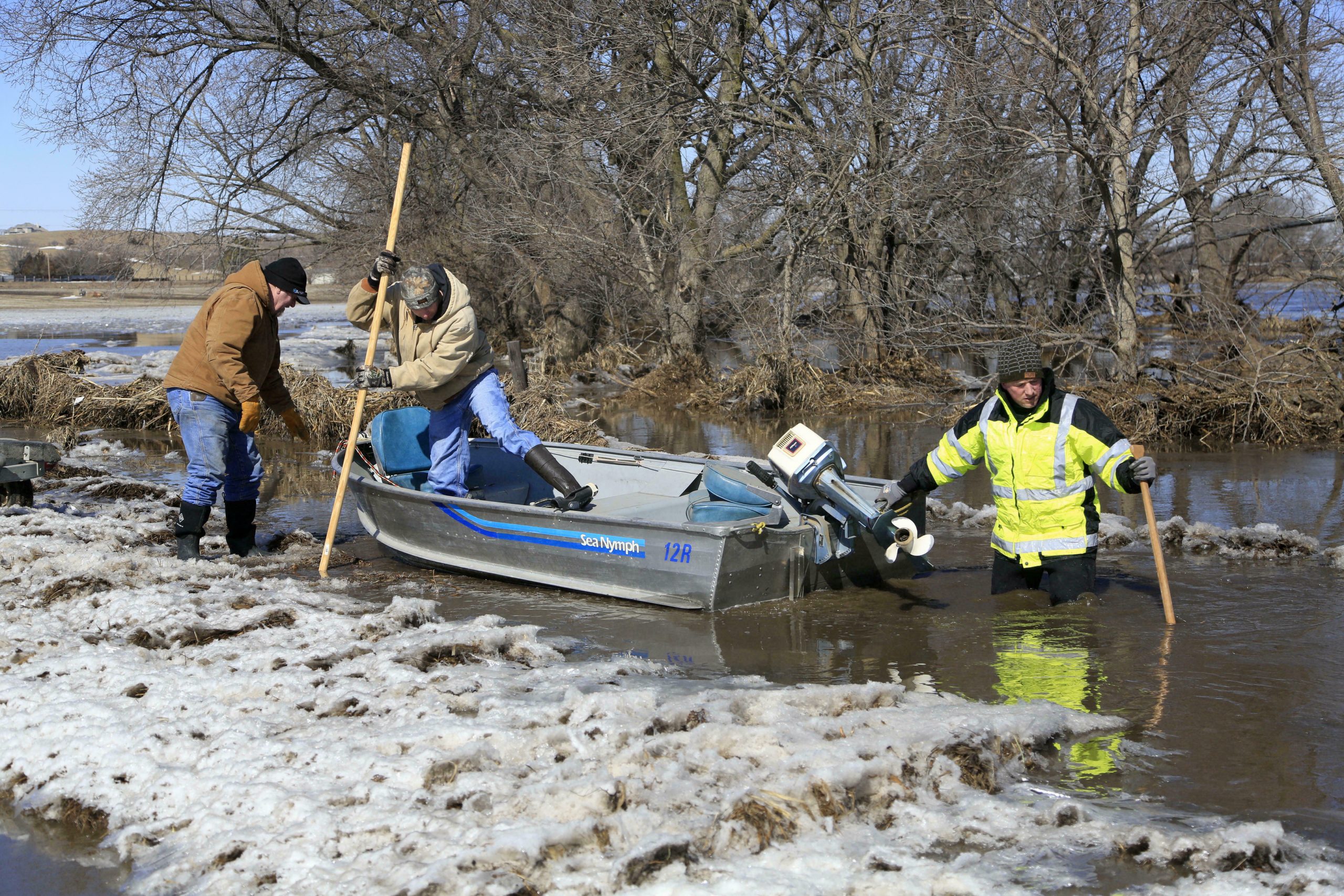 Tom Wilke, left, his son Chad, center, and Nick Kenny, launch a boat into the swollen waters of the North Fork of the Elkhorn River, to check on Wilke's flooded property, in Norfolk, Neb., Friday, March 15, 2019. Heavy rain falling atop deeply frozen ground has prompted evacuations along swollen rivers in Wisconsin, Nebraska and other Midwestern states. Thousands of people have been urged to evacuate along eastern Nebraska rivers as a massive late-winter storm has pushed streams and rivers out of their banks throughout the Midwest. 