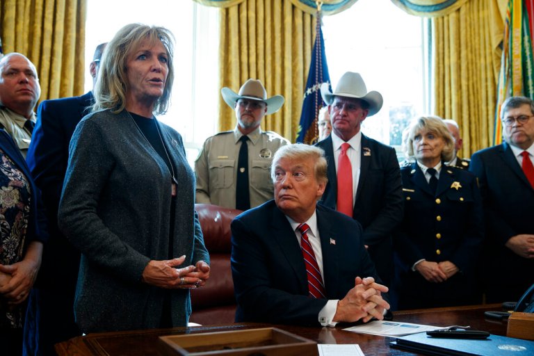 President Donald Trump listens as Mary Ann Mendoza, an 
