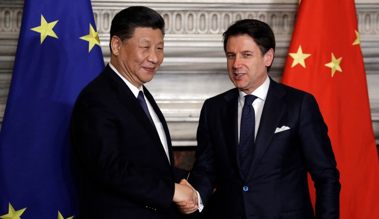 Chinese President Xi Jinping, left, and Italian Premier Giuseppe Conte shake their hands.