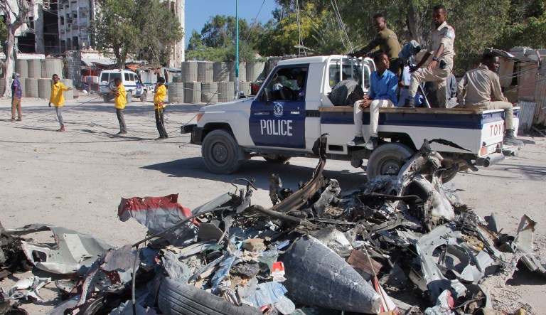 A police vehicle drives past wreckage after a suicide car bomb attack on a government building in the capital Mogadishu, Somalia, Saturday, March 23, 2019.