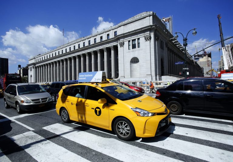 FILE - In this Aug. 15, 2016 file photo, a taxi drives past the James A Farley Post Office Building in New York. (AP Photo/Mark Lennihan, File)