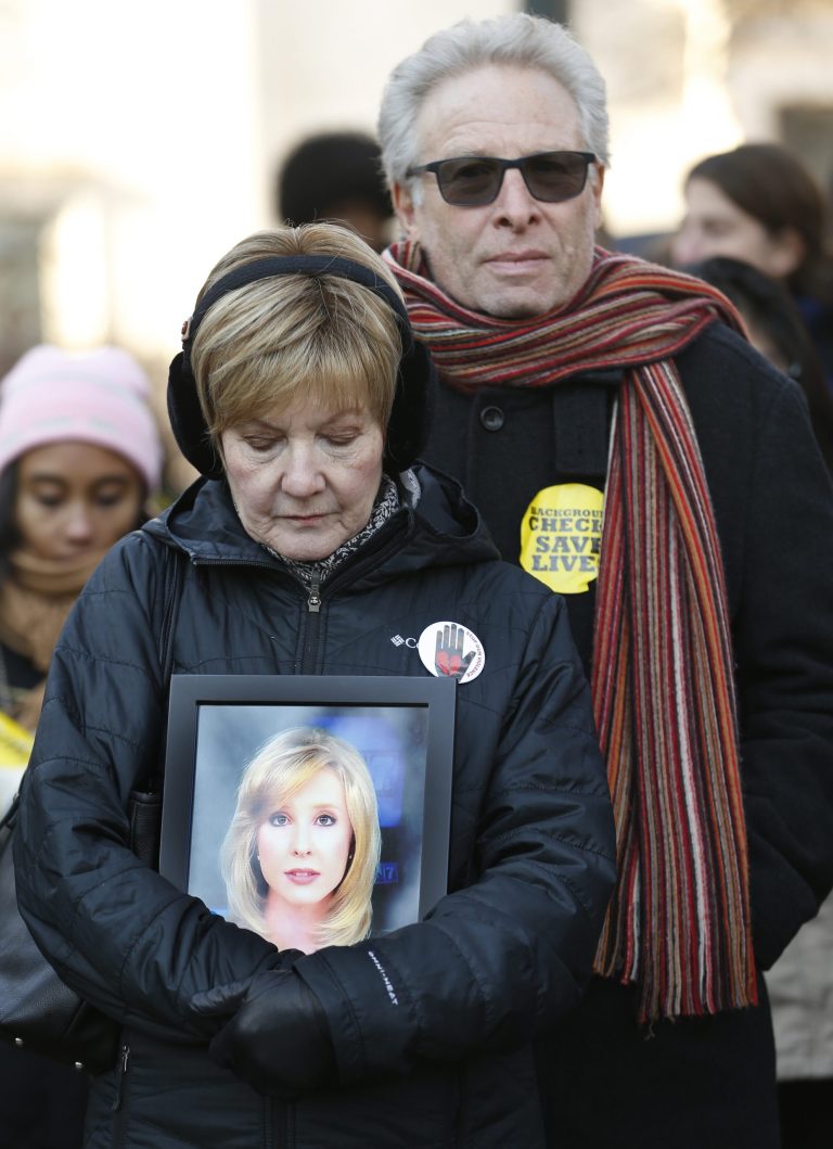 In this Jan. 15, 2018, photo, the parents of slain TV reporter Alison Parker, Barbara and Andy Parker, listen to speeches as they hold a photo of their daughter during an anti-gun violence rally at the Capitol in Richmond, Virginia.