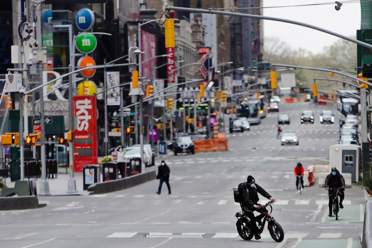 Pedestrians and cyclists move through Times Square Friday in New York. New York City streets are largely empty as people continue to stay at home to prevent the spread of COVID-19.