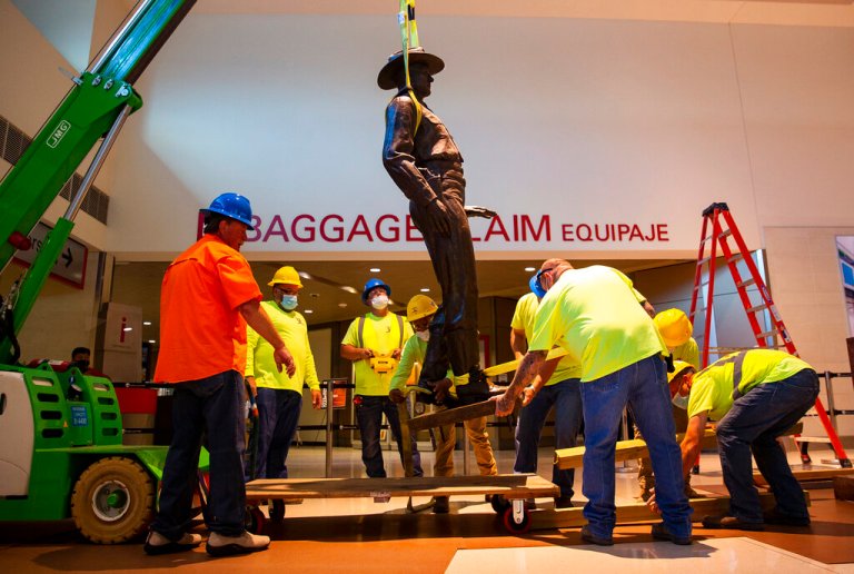 A Phoenix 1 Restoration & Construction crew removes a 12-foot-tall bronze statue of a Texas Ranger, called âOne Riot, One Ranger,â  from the main lobby inside Love Field airport on Thursday, June 4, 2020 in Dallas. ]