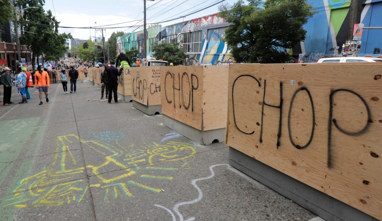 New cement and wood barricades bear the name CHOP, Tuesday, June 16, 2020, inside what has been named the Capitol Hill Occupied Protest zone in Seattle. The city put the barriers in place Tuesday in hopes of defining an area where emergency, delivery, and other vehicles can travel through the area while still preserving space for protesters, who have been there since police pulled back from near the department's East Precinct after recent clashes with people protesting the death of George Floyd. 