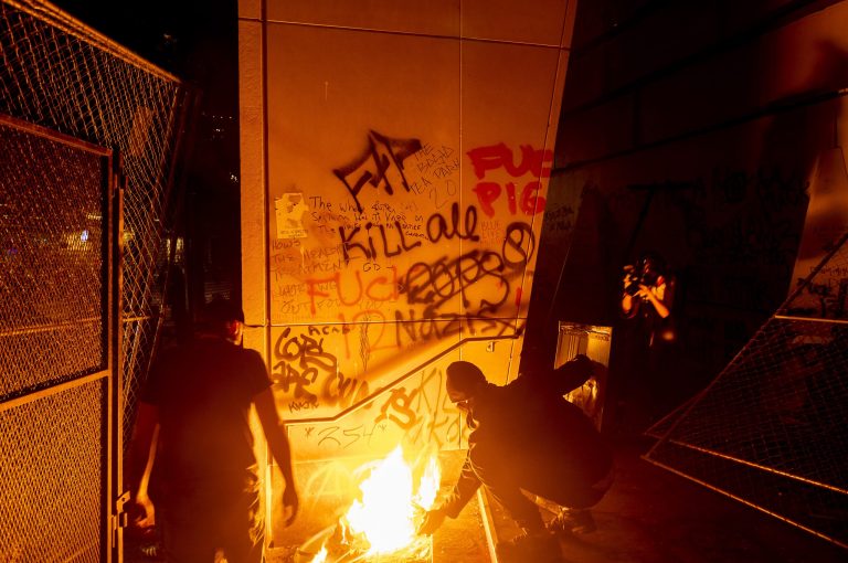 Black Lives Matter protesters burn signs outside the Mark O. Hatfield United States Courthouse.