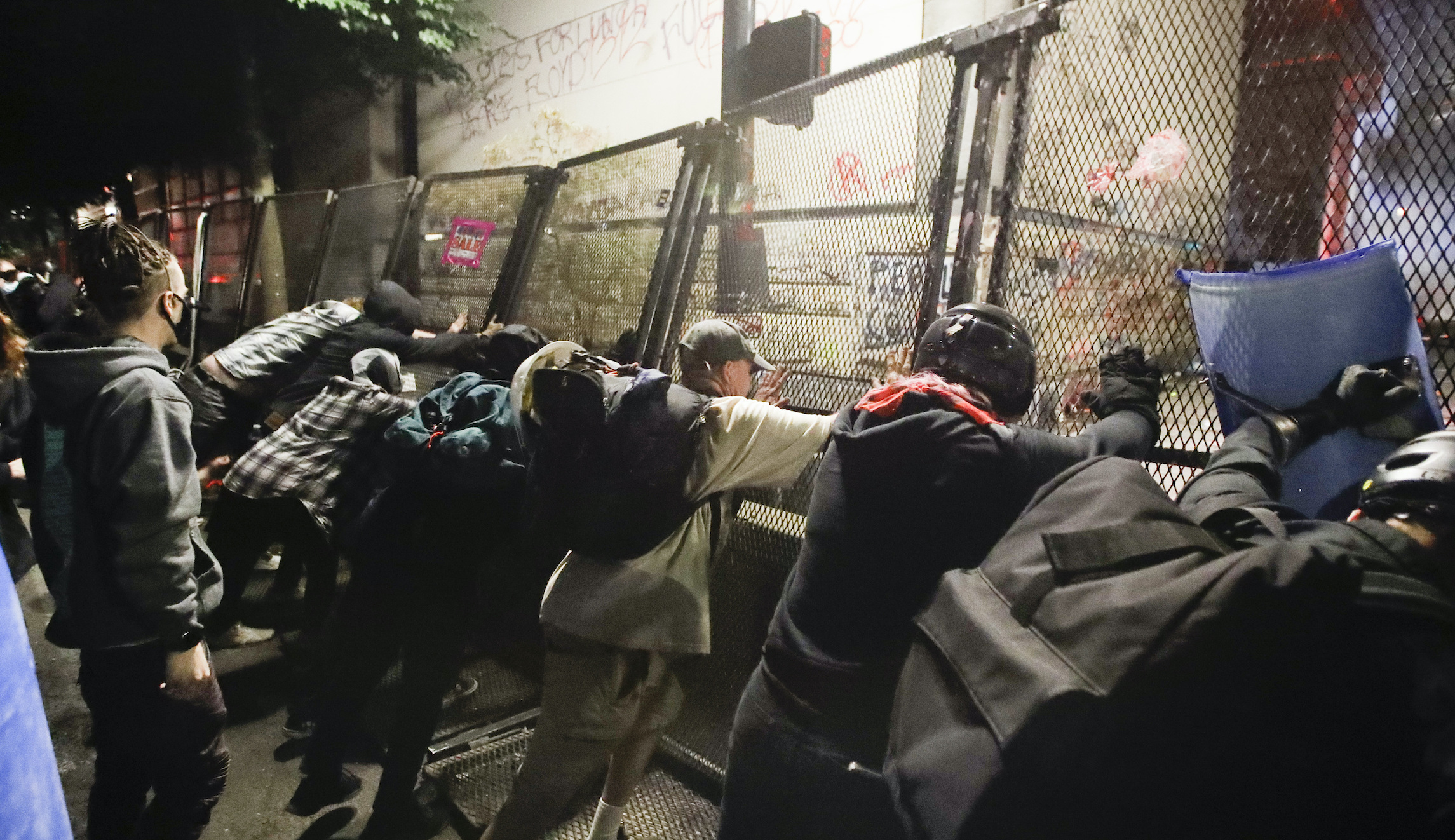 Portland police declare riot after protesters topple courthouse fence with chain