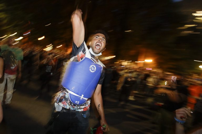 A demonstrator yells out slogans during a Black Lives Matter protest at the Mark O. Hatfield United States Courthouse Wednesday, July 29, 2020, in Portland, Ore. Images like this are scaring some from going out to cities.