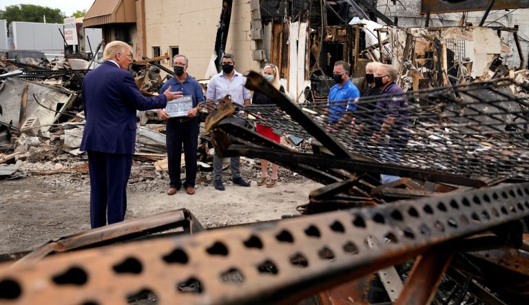 President Donald Trump talks with business owners Tuesday, Sept. 1, 2020, as he tours an area damaged during demonstrations after a police officer shot Jacob Blake in Kenosha, Wis.