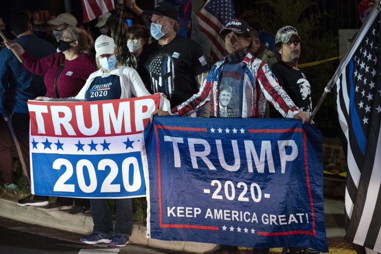 Supporters of President Donald Trump cheer at the main gate of Walter Reed National Military Medical Center in Bethesda, Md., late Friday, Oct. 2, 2020. Stricken by COVID-19, Trump was flown to Walter Reed on Friday night.