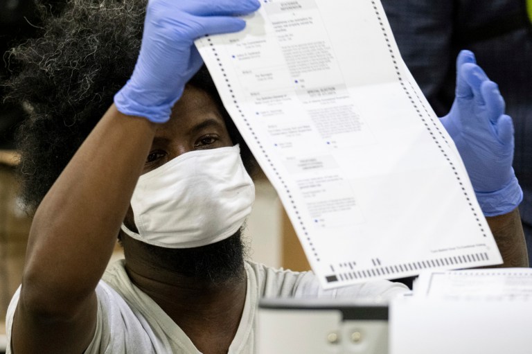 Workers scan ballots as the Fulton County presidential recount gets under way Wednesday morning, Nov. 25, 2020 at the Georgia World Congress Center in Atlanta.
