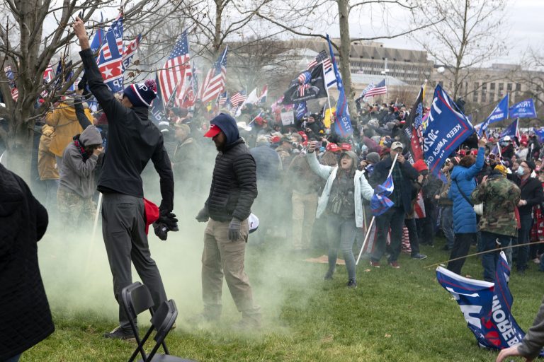 Supporters of President Donald Trump protest as U.S. Capitol Police officers shoot tear gas at demonstrators outside of the U.S. Capitol in Washington Wednesday.