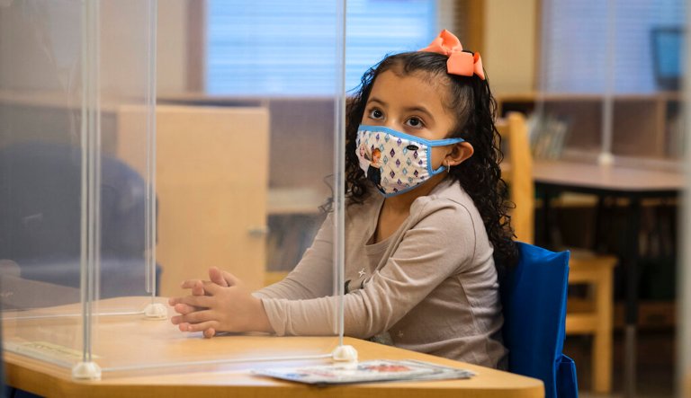 A preschool student listens as her teacher talks during class at Dawes Elementary School in Chicago, Monday, Jan. 11, 2021. Monday was the first day of optional in-person learning for preschoolers and some special education students in Chicago Public Schools after going remote last March due to the coronavirus pandemic. 