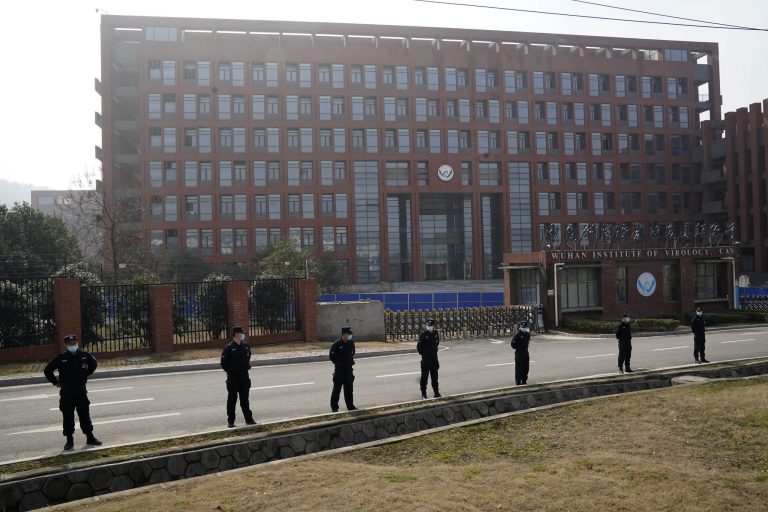 Security personnel gather near the entrance to the Wuhan Institute of Virology during a visit by the World Health Organization team in Wuhan in China's Hubei province on Wednesday, Feb. 3, 2021. 