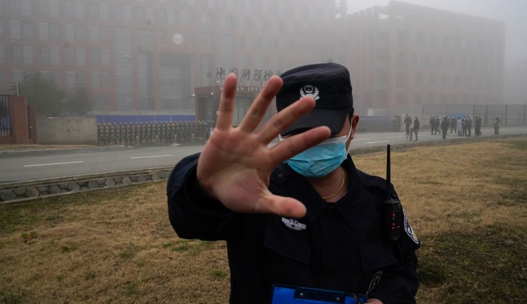 Security moves journalists away from the Wuhan Institute of Virology after a World Health Organization team arrived for a field visit.