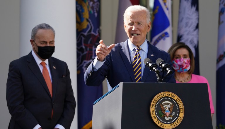 President Joe Biden speaks about the American Rescue Plan, a coronavirus relief package, in the Rose Garden of the White House, Friday, March 12, 2021, in Washington. Senate Majority Leader Chuck Schumer of N.Y., left, and House Speaker Nancy Pelosi of Calif., listen.