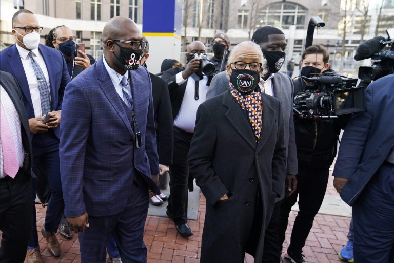 The Rev. Al Sharpton, foreground right, arrives with attorneys and George Floyd family members for a news conference outside the Hennepin County Government Center Monday, March 29, 2021, in Minneapolis. (AP Photo/Jim Mone)