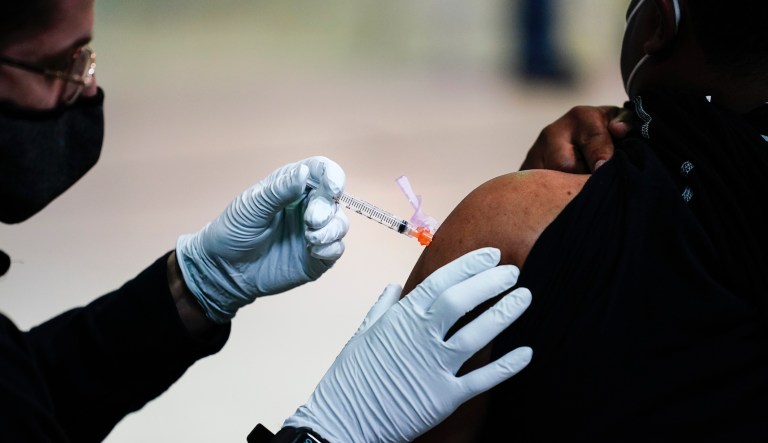 A member of the Philadelphia Fire Department administers the Johnson & Johnson COVID-19 vaccine to a person at a vaccination site setup at a Salvation Army location in Philadelphia, Friday, March 26, 2021.