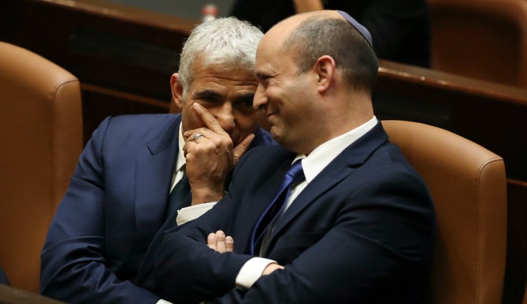 Israel's new prime minister Naftali Bennett sits with Yair Lapid, left, during a Knesset session in Jerusalem Sunday, June 13, 2021. Israel's parliament has voted in favor of a new coalition government, formally ending Prime Minister Benjamin Netanyahu's historic 12-year rule. Naftali Bennett, a former ally of Netanyahu became the new prime minister.