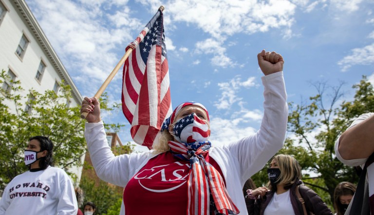 In this May 12, 2021 file photo, Ivania Castillo raises her fist during a a protest for the immigration reform with the advocacy group CASA, outside of the Republican National Committee building in Washington. The protest, which included activists and undocumented immigrants from throughout the Mid-Atlantic region, was aimed at President Joe Biden, asking him to ensure citizenship and greater legal protection to undocumented workers.