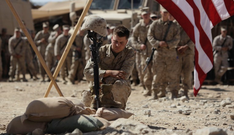 U.S. Marine Cpl. Russell pays his respects to Lance Cpl. Joshua Bernard during a memorial service at a forward operating base with Golf Company, 2nd Battalion, 3rd Regiment, 2nd MEB, 3rd MEF, Thursday, Aug. 27, 2009, in Now Zad in the Helmand Province of Afghanistan. Bernard was killed during a Taliban ambush on Aug. 14.