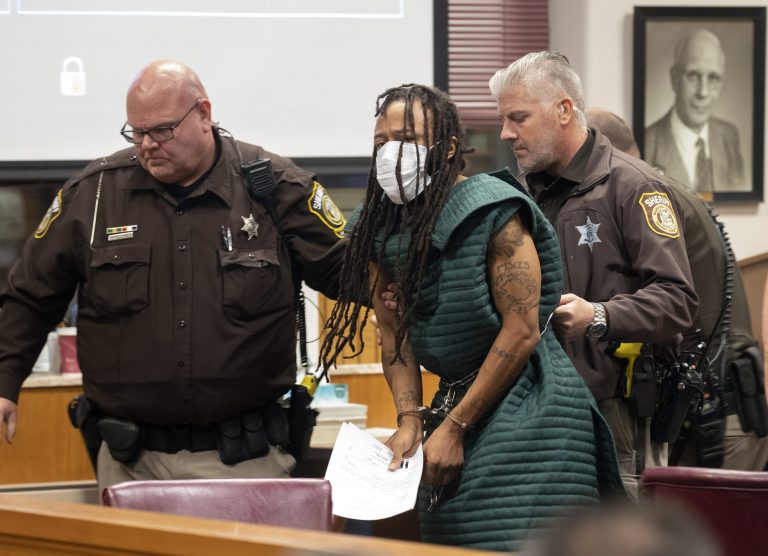 Darrell Brooks, center, is escorted out of the courtroom after making his initial appearance in a case regarding multiple people who were killed or injured when an SUV was driven into a Christmas parade, in Waukesha County Court, Tuesday, Nov. 23, 2021, in Waukesha, Wisconsin.