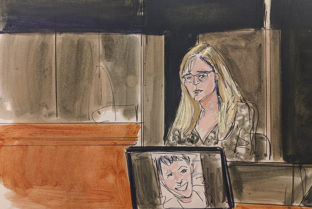 In this courtroom sketch, Annie Farmer testifies on the witness stand during the Ghislaine Maxwell sex abuse trial Friday in New York. A photo of Maxwell appears on a screen in the foreground.