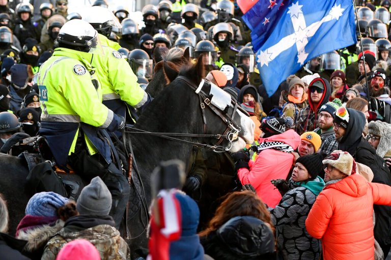 Protesters react as Toronto Police mounted unit move in to disperse them as police take action to put an end to a protest, which started in opposition to mandatory COVID-19 vaccine mandates and grew into a broader anti-government demonstration and occupation, Friday, Feb. 18, 2022, in Ottawa.