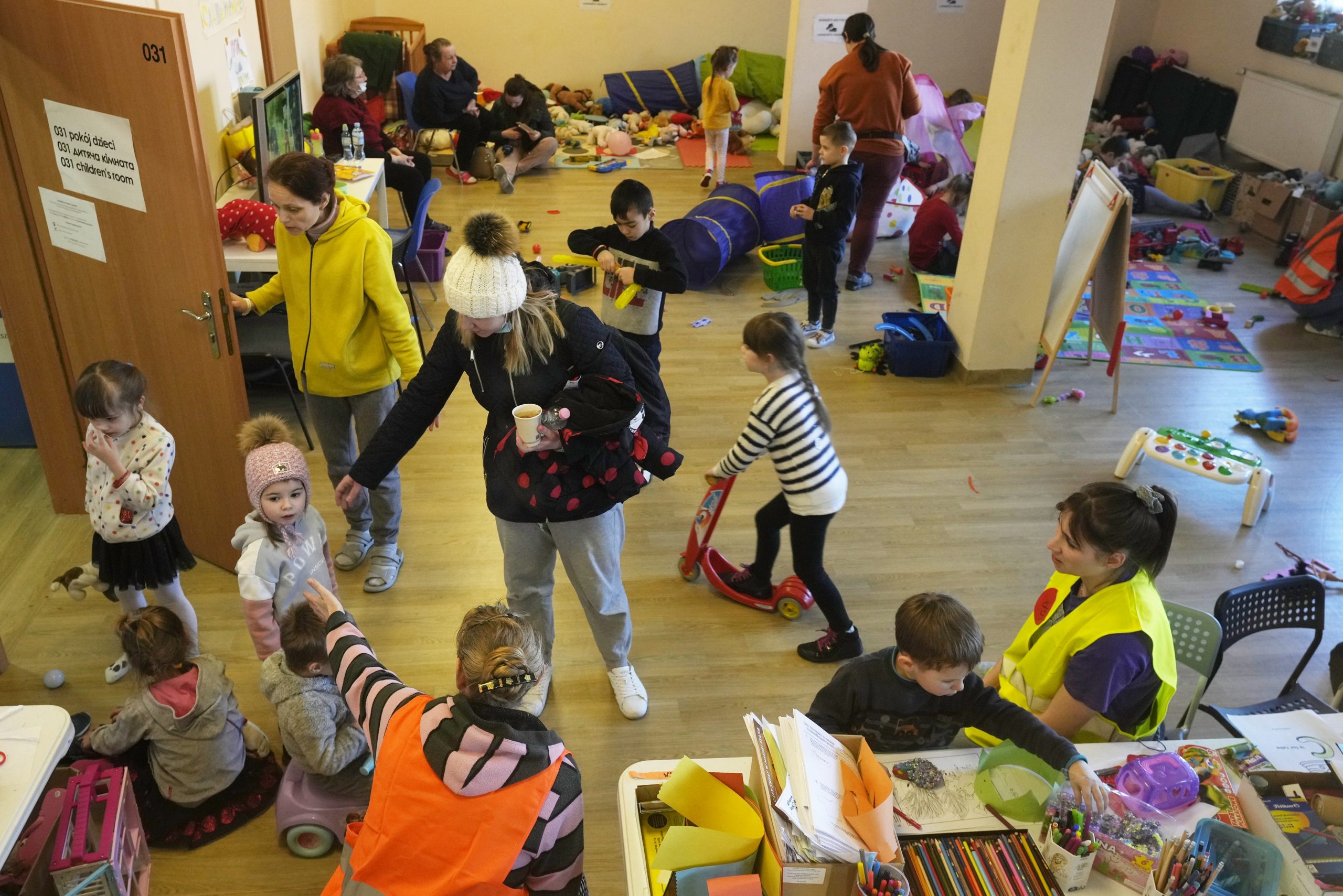 Volunteers entertain children who fled the war in Ukraine at a sports center that has been turned into an accommodation center in Warsaw, Poland, on Friday. Warsaw has become overwhelmed by refugees, with more than a tenth of all those fleeing the war in Ukraine arriving in the Polish capital. This situation has prompted Warsaw's mayor to appeal for international help. 