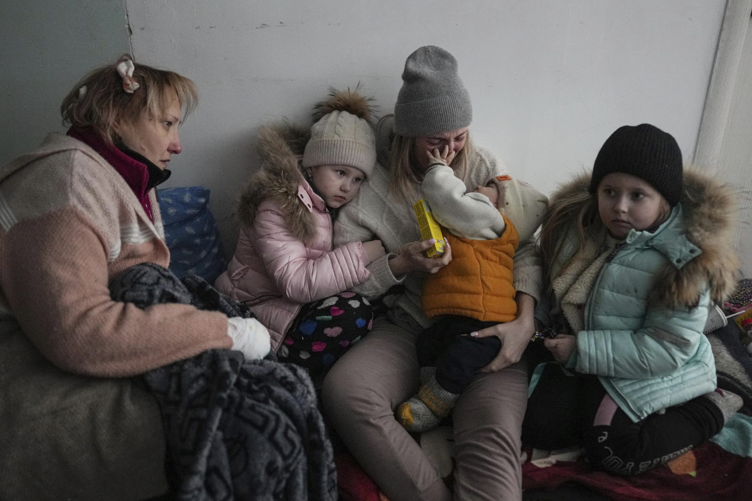 Women and children sit on the floor of a corridor in a hospital in Mariupol, eastern Ukraine, on Friday. Mariupol has been under siege for over a week, with no electricity, gas, or water. Repeated efforts to evacuate people from the city of 430,000 have fallen apart as humanitarian convoys come under shelling. 