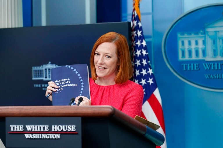 White House press secretary Jen Psaki holds up a COVID-19 preparedness book as she speaks during the daily briefing at the White House in Washington, Thursday, April 7, 2022.
