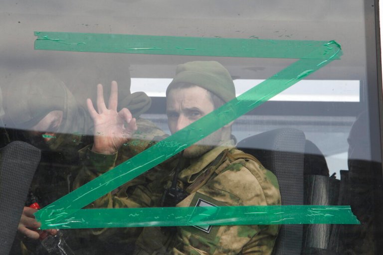 A serviceman gestures as he looks from a bus window with the letter Z in Chechnya's regional capital of Grozny, Russia, Friday, April 8, 2022.