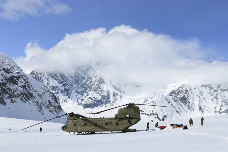 Personnel offload equipment and supplies from a CH-47 Chinook helicopter in Alaska.