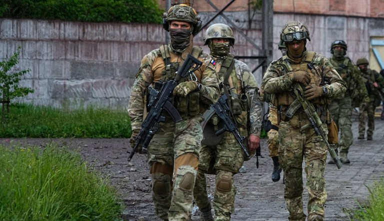 Russian troops walk at a destroyed part of the Illich Iron & Steel Works Metallurgical Plant in Mariupol, in territory under the government of the Donetsk People's Republic, eastern Ukraine, Wednesday, May 18, 2022.