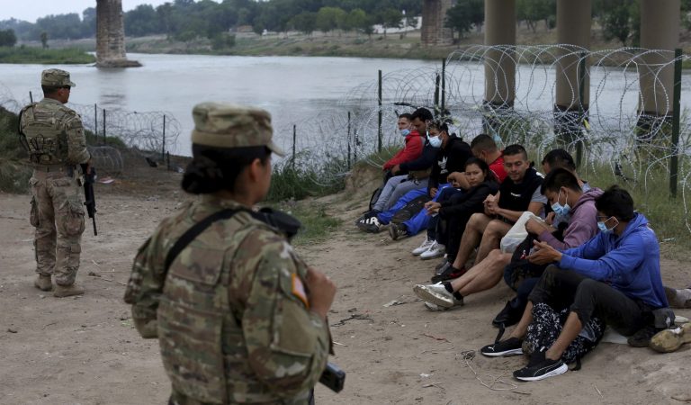 Immigrants who had crossed the Rio Grande into the U.S. are under custody of National Guard members.