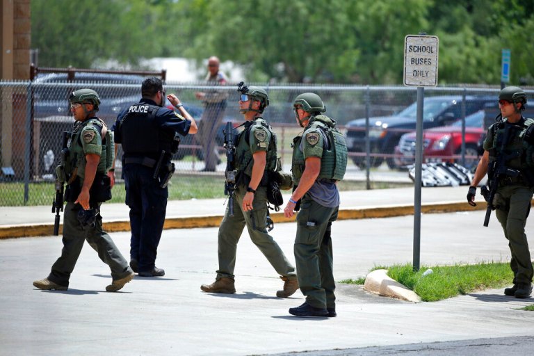 Law enforcement personnel stand outside Robb Elementary School.