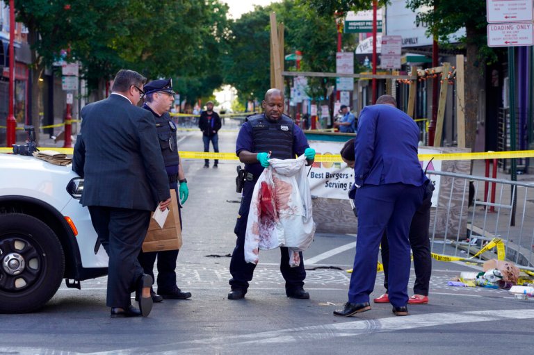 Philadelphia Police investigators work the scene of a fatal overnight shooting on South Street in Philadelphia, Sunday, June 5, 2022.