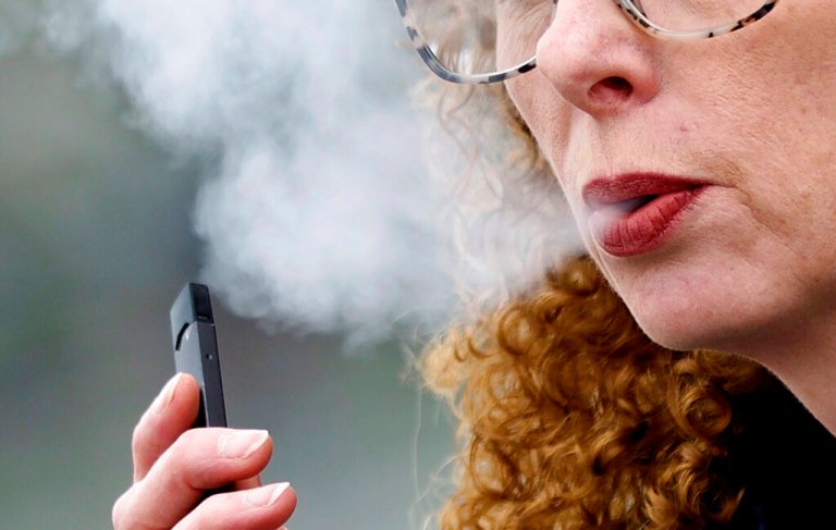 A woman exhales while vaping from a Juul pen e-cigarette in Vancouver, Wash., April 16, 2019. Juul has asked a federal court, Friday, June 24, 2022, to block a government order to stop selling its electronic cigarettes. 