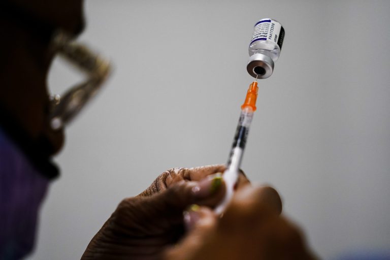 A syringe is prepared with the Pfizer COVID-19 vaccine at a vaccination clinic at the Keystone First Wellness Center in Chester, Pa., Dec. 15, 2021.  Pfizer says tweaking its COVID-19 vaccine to better target the omicron variant is safe and boosts protection.