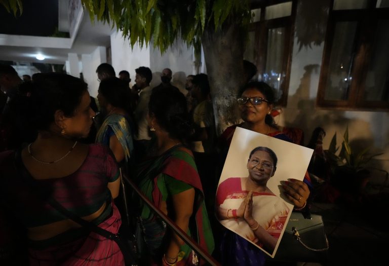 A woman holds a photograph of Droupadi Murmu.