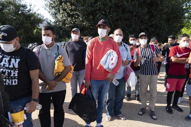 Immigrants hold Red Cross blankets after arriving at Union Station near the U.S. Capitol from Texas on buses.