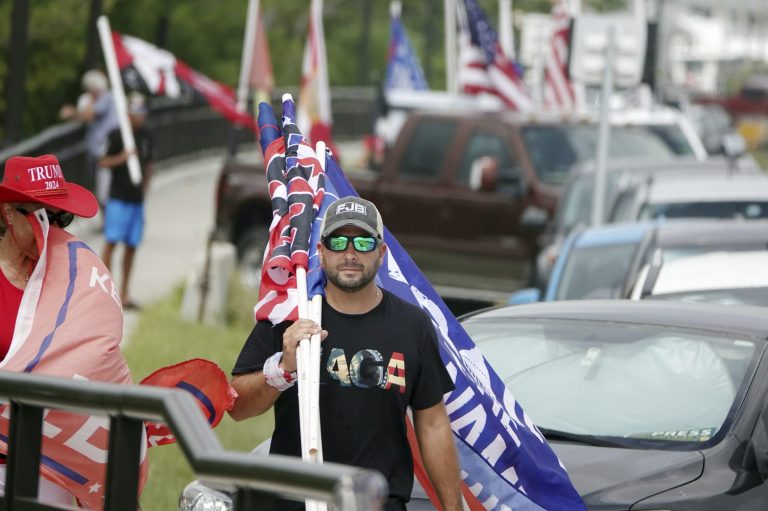 Supporters of former President Donald Trump walk near Mar-a-Lago, Tuesday, to protest the FBI raid of Trump's Florida estate. 