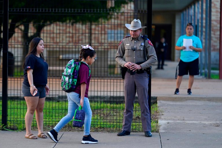 Students arrive at Uvalde Elementary, now protected by a fence and Texas state troopers, for the first day of school.