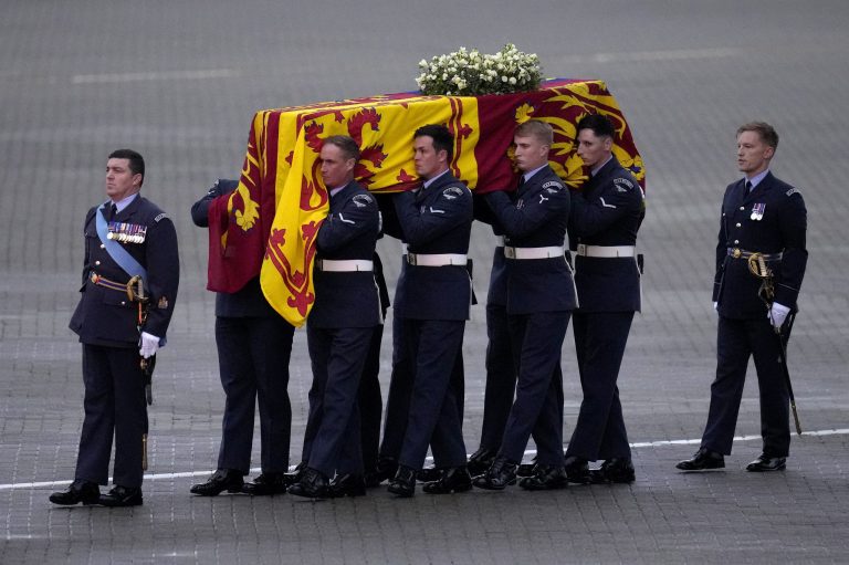 The coffin of Queen Elizabeth II is carried off a plane.