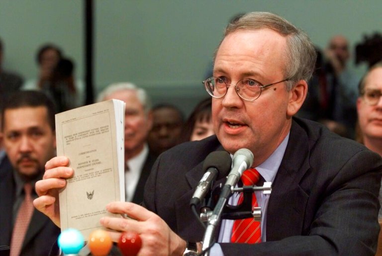 Ken Starr holds a copy of his report while testifying on Capitol Hill in 1998.