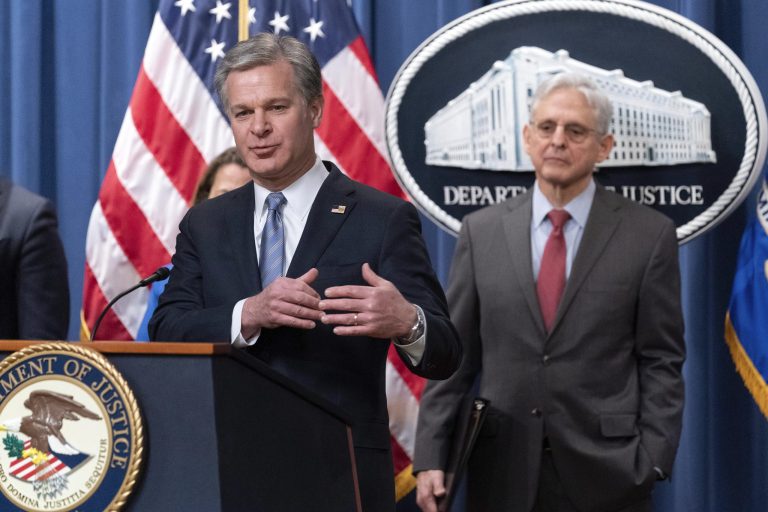 FBI Director Christopher Wray flanked by Attorney General Merrick Garland speaks during a news conference to announce an international ransomware enforcement action, at the Department of Justice in Washington, Thursday, Jan. 26, 2023. The FBI has seized the website of a prolific ransomware gang that has heavily targeted hospitals and other healthcare providers. 